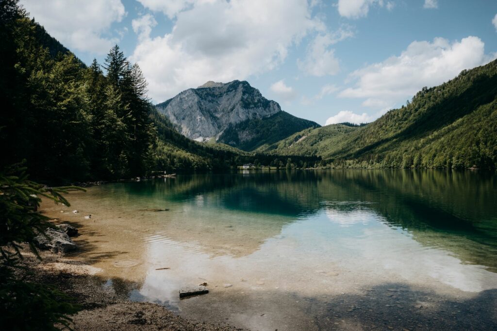 Tranquil mountain lake reflecting lush greenery and clear sky in Ebensee, Österreich