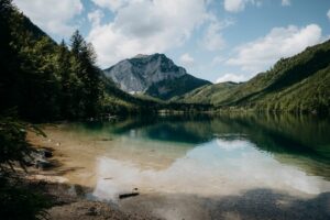 Tranquil mountain lake reflecting lush greenery and clear sky in Ebensee, Österreich
